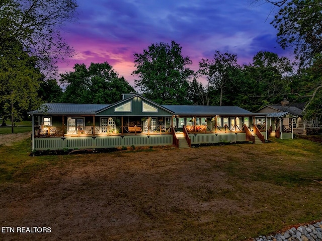4225 W Lakeview Cir, Louisville, TN 37777 - back of house at dusk with covered porch, a deck, a yard, and metal roof