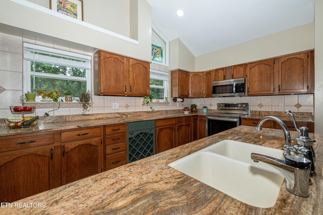 4225 W Lakeview Cir, Louisville, TN 37777 - kitchen with stainless steel appliances, a sink, brown cabinets, light stone counters, and tasteful backsplash