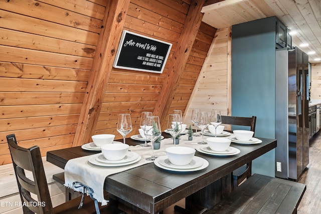 dining space with wood walls, wood ceiling, and wood finished floors
