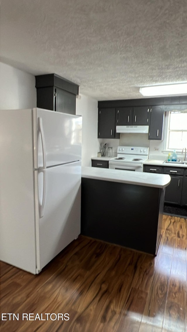 798 Lawson Rd, Crossville, TN 38571 - kitchen with white appliances, dark cabinets, under cabinet range hood, dark wood-style floors, and a textured ceiling