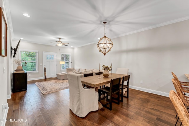 dining area featuring dark wood-style flooring, ceiling fan with notable chandelier, baseboards, ornamental molding, and recessed lighting