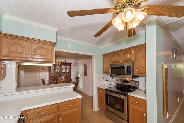 1211 Old Hollow Rd, Loudon, TN 37774 - kitchen featuring ornamental molding, light countertops, a ceiling fan, stainless steel appliances, and light wood-style flooring