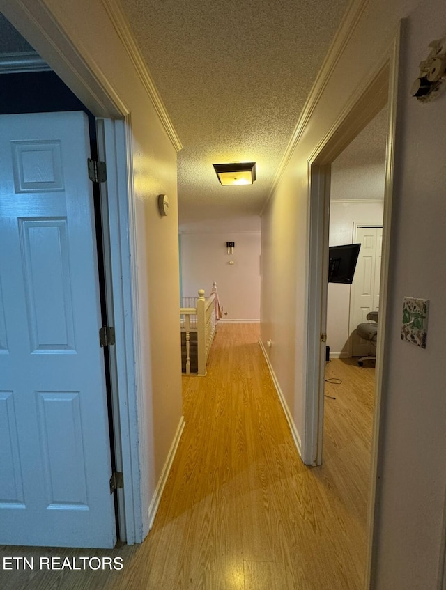 1211 Old Hollow Rd, Loudon, TN 37774 - hallway featuring light wood-style flooring, ornamental molding, a textured ceiling, an upstairs landing, and baseboards