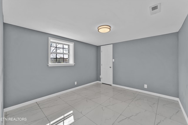 unfurnished room with visible vents, marble finish floor, and baseboards
