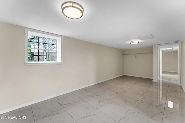 empty room featuring baseboards and marble finish floor