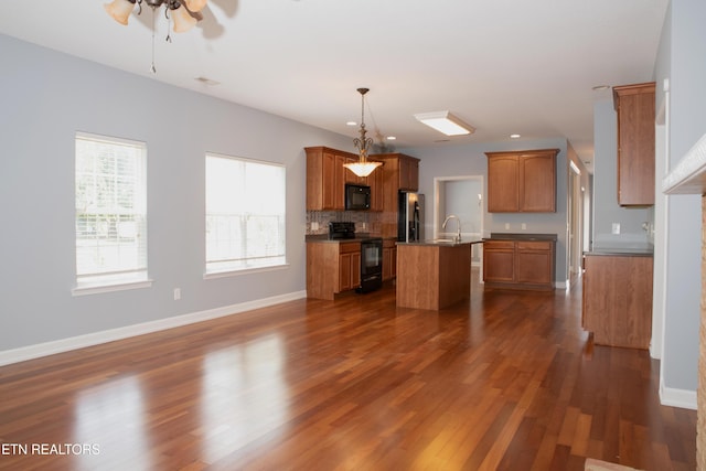 129 Mcneilly Cir, Maryville, TN 37803 - kitchen featuring an island with sink, ceiling fan, dark wood finished floors, black appliances, and baseboards