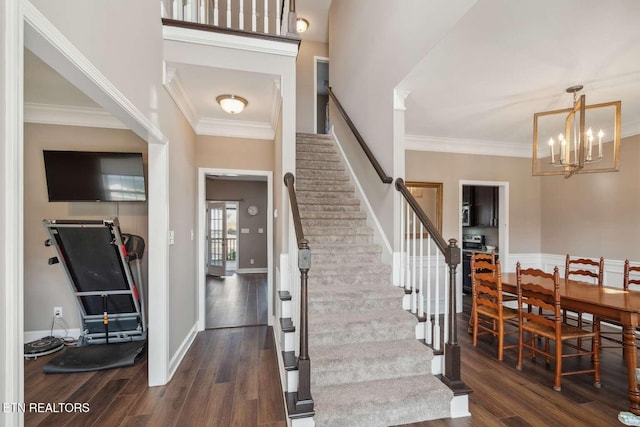 foyer with a chandelier, stairway, ornamental molding, and wood finished floors