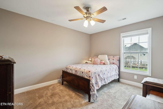 carpeted bedroom featuring visible vents, baseboards, and ceiling fan