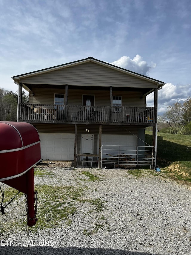 view of front of house featuring an attached garage and gravel driveway