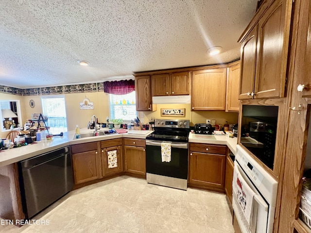 801 Lakeway Rd, Morristown, TN 37814 - kitchen with under cabinet range hood, light countertops, a sink, washer / dryer, and stainless steel appliances