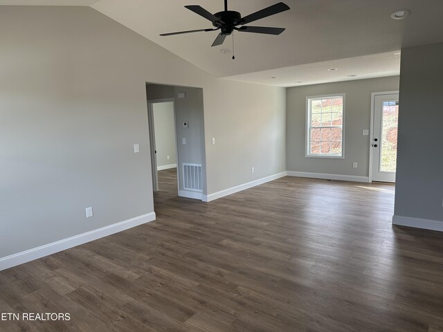 spare room with ceiling fan, vaulted ceiling, visible vents, dark wood-style flooring, and baseboards