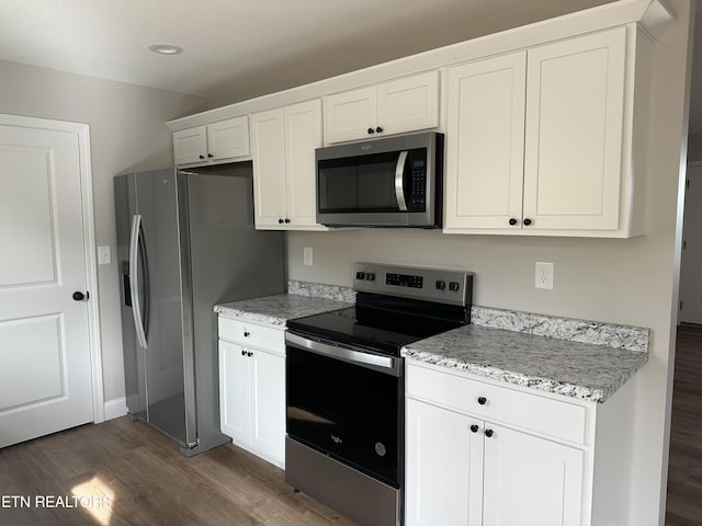 kitchen featuring stainless steel appliances, light stone countertops, dark wood-style floors, and white cabinets