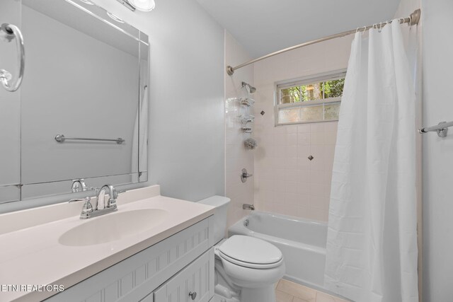 bathroom featuring toilet, vanity, tile patterned flooring, and shower / tub combo with curtain