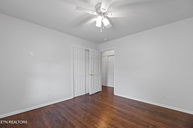 unfurnished bedroom with a closet, baseboards, a ceiling fan, and wood finished floors