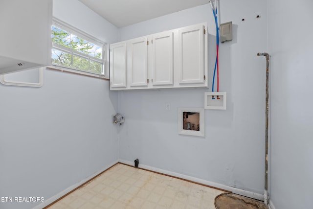 laundry area featuring tile patterned floors, baseboards, hookup for a washing machine, and cabinet space