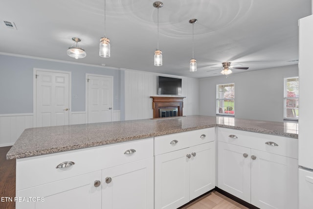 kitchen featuring light stone counters, open floor plan, a ceiling fan, visible vents, and light wood finished floors