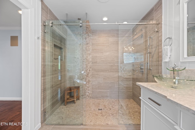 bathroom with a chandelier, crown molding, recessed lighting, vanity, and a stall shower