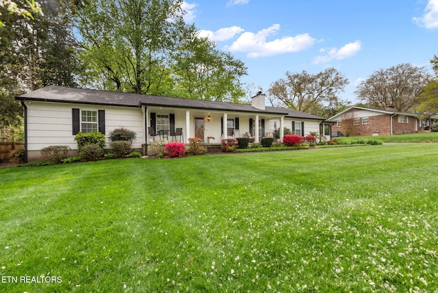 ranch-style house featuring a porch, a front lawn, and a chimney