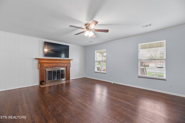 unfurnished living room featuring visible vents, a ceiling fan, crown molding, wood finished floors, and a glass covered fireplace