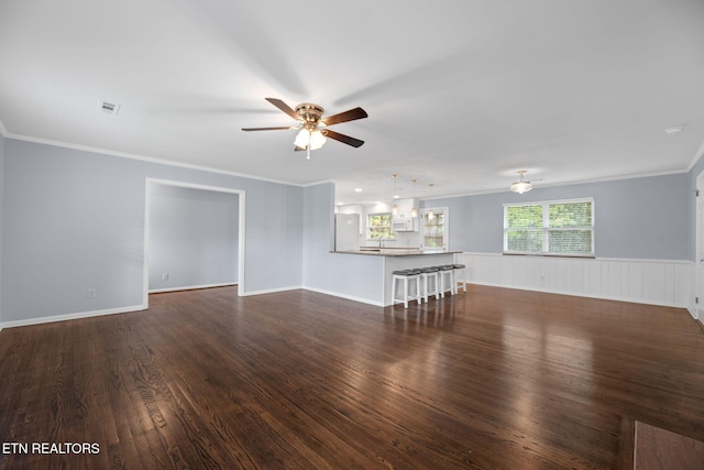 unfurnished living room with dark wood finished floors, visible vents, crown molding, and ceiling fan