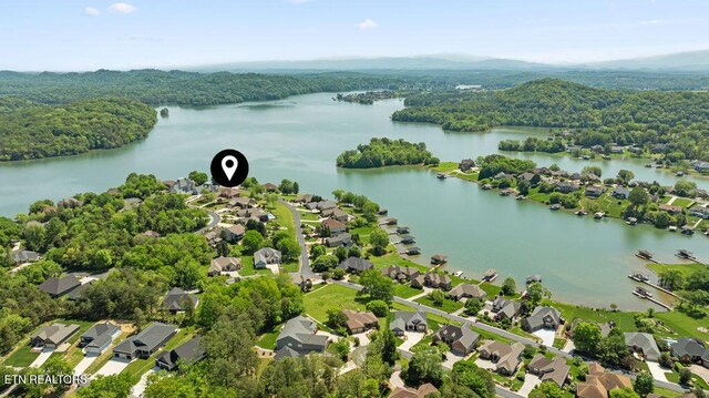 birds eye view of property with a water view, a residential view, and a wooded view