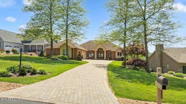 view of front facade featuring a garage, driveway, and a front lawn