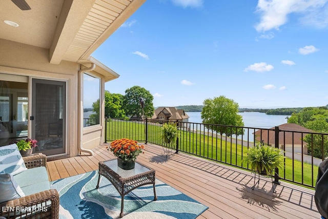 wooden deck featuring a lawn and a water view
