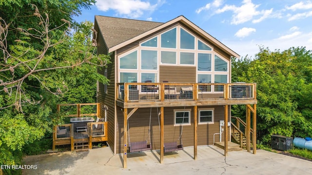 back of house featuring a patio, a shingled roof, and a deck