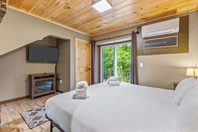bedroom featuring a wall mounted air conditioner, baseboards, wooden ceiling, and wood finished floors