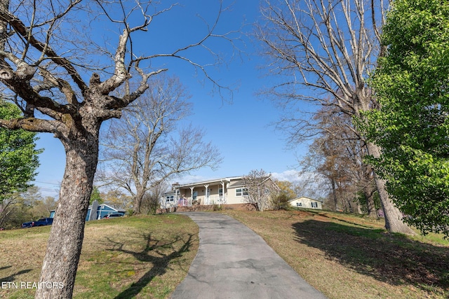 view of front of property with a porch, a front lawn, and aphalt driveway