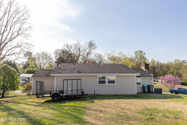 rear view of property featuring a lawn and a chimney