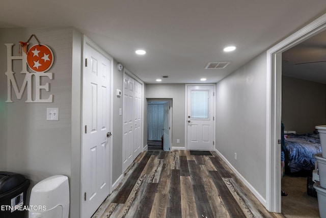 hallway with recessed lighting, visible vents, baseboards, and wood finished floors