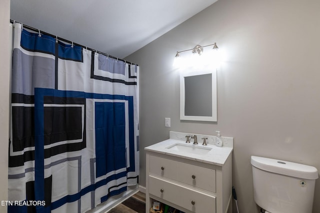 bathroom with curtained shower, vanity, vaulted ceiling, and toilet
