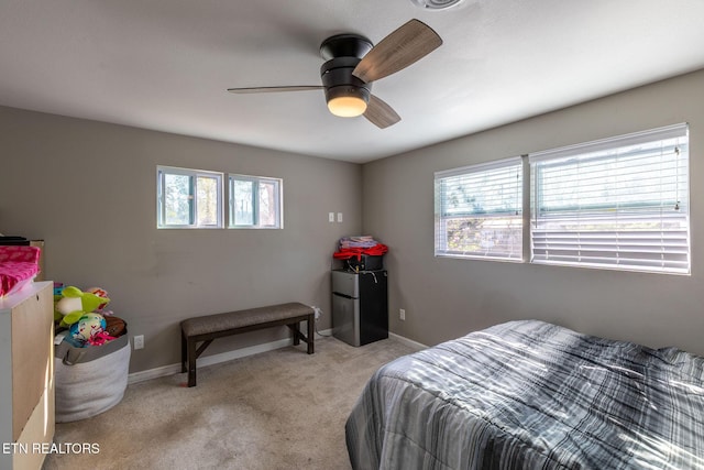 bedroom featuring baseboards, a ceiling fan, and light colored carpet