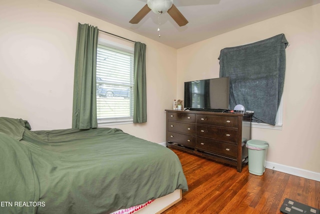 bedroom featuring ceiling fan, baseboards, and wood finished floors