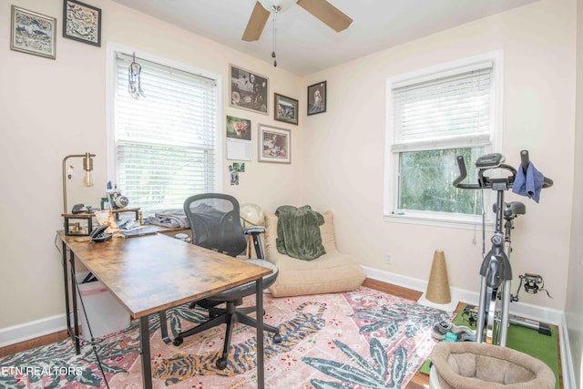 home office featuring ceiling fan, a wealth of natural light, wood finished floors, and baseboards
