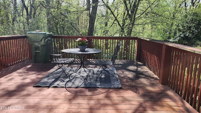 wooden terrace featuring a forest view