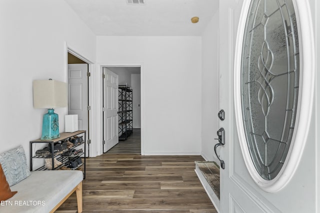 foyer entrance with baseboards, dark wood finished floors, and visible vents