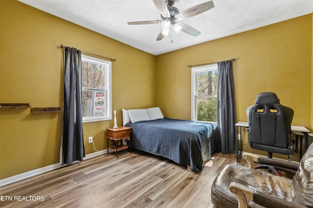 bedroom featuring ceiling fan, baseboards, and wood finished floors