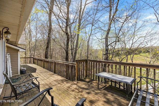 wooden terrace featuring a wooded view