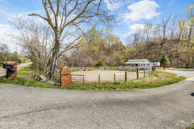 view of street featuring a wooded view and an enclosed area