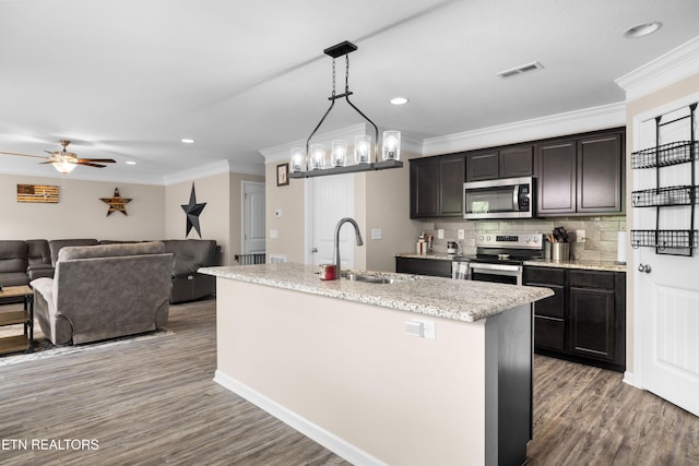 5811 Rain Cloud Rd, Knoxville, TN 37918 - kitchen with appliances with stainless steel finishes, ornamental molding, wood finished floors, recessed lighting, and a kitchen island with sink
