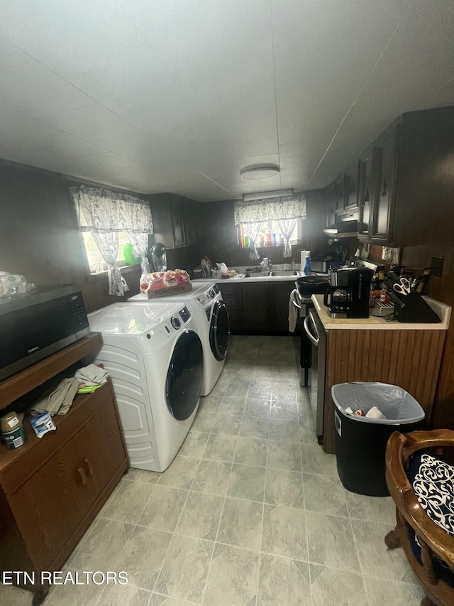 laundry area with a sink, a wealth of natural light, washer and dryer, and laundry area