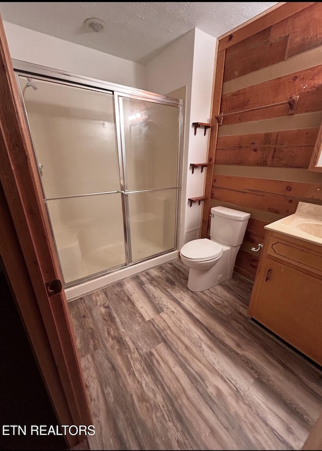 116 Old Doc Rogers Rd, Tellico Plains, TN 37385 - bathroom with vanity, wood finished floors, toilet, a textured ceiling, and a shower stall