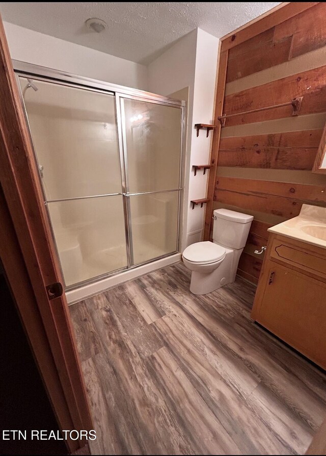 116 Old Doc Rogers Rd, Tellico Plains, TN 37385 - bathroom with vanity, wood finished floors, toilet, a textured ceiling, and a shower stall