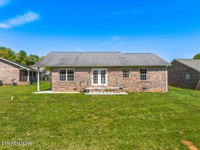 rear view of house with crawl space, french doors, a lawn, a patio area, and brick siding