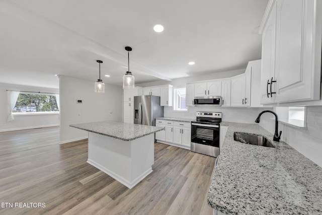 9204 Chamaeleon Trl, Harrison, TN 37341 - kitchen featuring a sink, light wood finished floors, white cabinetry, stainless steel appliances, and a kitchen island