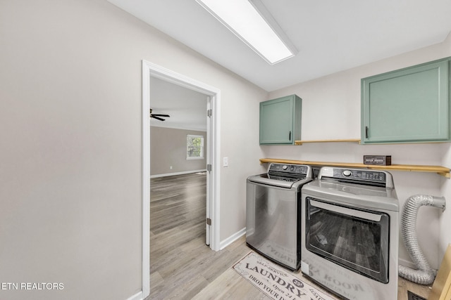 9204 Chamaeleon Trl, Harrison, TN 37341 - clothes washing area with light wood-type flooring, washer and clothes dryer, baseboards, and cabinet space
