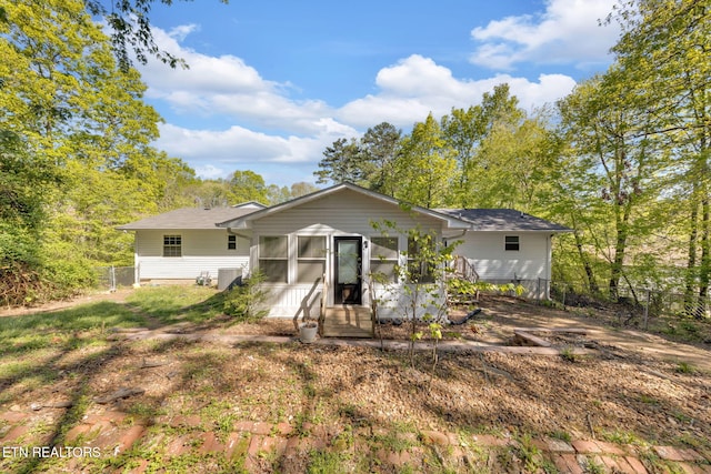 9204 Chamaeleon Trl, Harrison, TN 37341 - rear view of property featuring a sunroom, roof with shingles, and fence