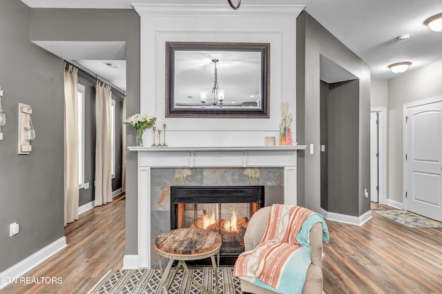 living area with wood finished floors, a fireplace, and baseboards